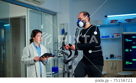 Slow motion shot of sport scientist looking at tablet with EKG scan 75156721