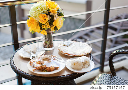 Room service with food and bouquet  of  flowers in vase on table at balcony 75157167