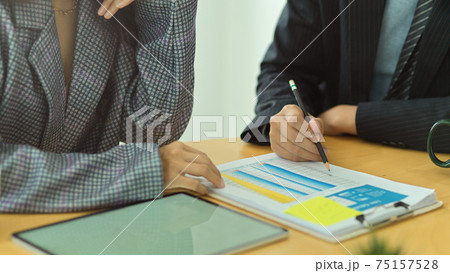 Businesspeople consulting on their business informations on the table in meeting room Businesspeople consulting on their business informations on the table in meeting room 75157528