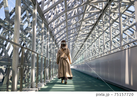 京都駅ビル空中経路を歩いている若い女性の後姿 京都駅ビル空中経路を歩いている若い女性の後姿 75157720