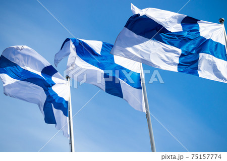 Three finnish national flags on the wind against the blue sky Three finnish national flags on the wind against the blue sky 75157774