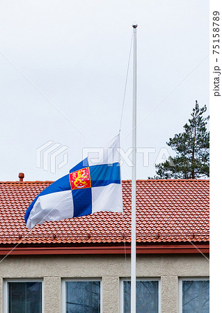 Finnish flag lowered to half mast on the occasion of mourning at cloudy autumn day 75158789