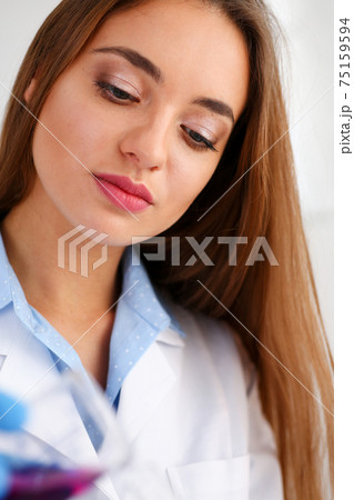 Technician hold in arms in protective gloves sample bottle 75159594