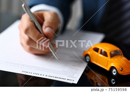 Male arm in suit filling insurance form lying on table 75159598