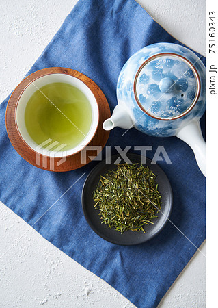 湯呑みに注がれた緑茶と茶葉 湯呑みに注がれた緑茶と茶葉 75160343