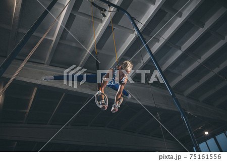 Little male gymnast training in gym, flexible and active. Caucasian fit little boy, athlete in sportswear practicing in exercises for strength, balance. 75161556