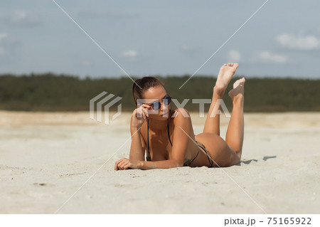 Seductive female resting on beach 75165922