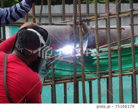 SELANGOR, MALAYSIA -MAY 16, 2017: Welder wearing protective mask during welding metal at the construction site. SELANGOR, MALAYSIA -MAY 16, 2017: Welder wearing protective mask during welding metal at the construction site. 75166176