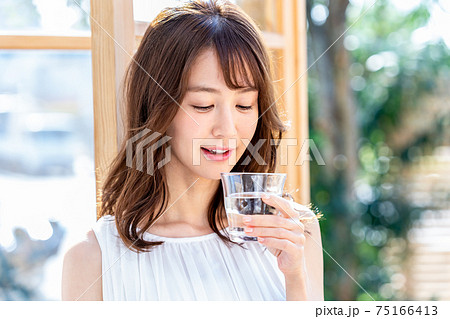 コップを持つ若い女性 75166413