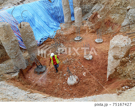 KUALA LUMPUR, MALAYSIA -JULY 30, 2020: Construction workers mixing and spraying the anti-termite chemical treatment to the soil at the construction site.  75167427