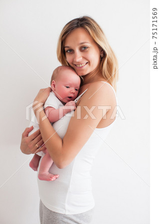 Pretty young smiling mother holding newborn baby 75171569