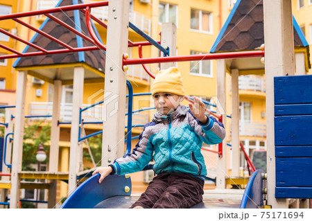 Sad boy play alone at playground outdoors Sad boy play alone at playground outdoors 75171694