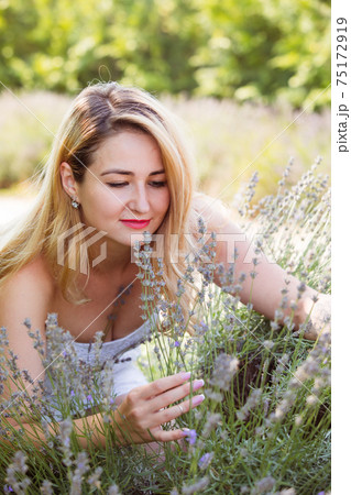 Woman posing outdoors at flowers market between hydrangea flowers Woman posing outdoors at flowers market between hydrangea flowers 75172919