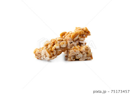 Kozinaki on a white background. Peanuts in caramel close-up. Eastern sweetness. 75173457