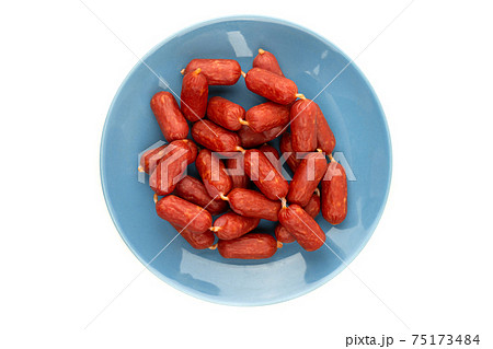Small smoked sausages on a white background. Grilled sausages close-up on a plate. Top view. Small smoked sausages on a white background. Grilled sausages close-up on a plate. Top view. 75173484