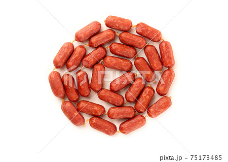 Small smoked sausages on a white background. Grilled sausages close-up on a white background. Top view. Small smoked sausages on a white background. Grilled sausages close-up on a white background. Top view. 75173485