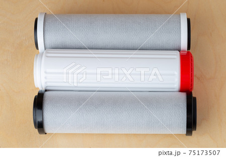 Water filters on a wooden background. New filters for water purification close-up. 75173507