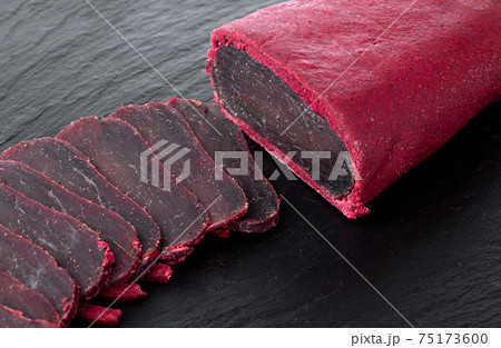 Cured meat on a slate board. Close-up of basturma sliced into pieces. Cured meat on a slate board. Close-up of basturma sliced into pieces. 75173600