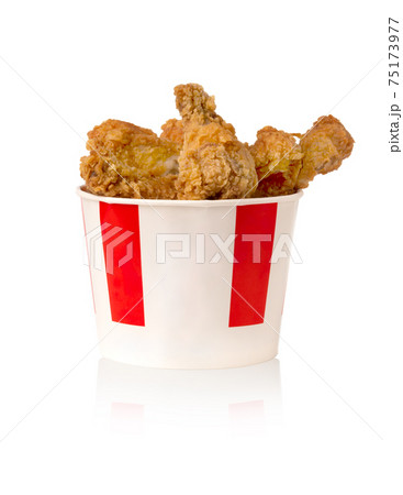 Fried legs and wings on a white background. Chicken wings and legs deep-fried in a cardboard bucket. 75173977