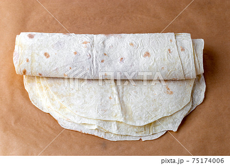 Thin pita bread on baking paper. Armenian pita bread close-up. 75174006