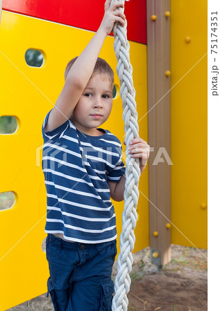 Child playing on outdoor playground. Kids play on school or kindergarten yard. Active kid on colorful monkey bars. Healthy summer activity for children. Child playing on outdoor playground. Kids play on school or kindergarten yard. Active kid on colorful monkey bars. Healthy summer activity for children. 75174351