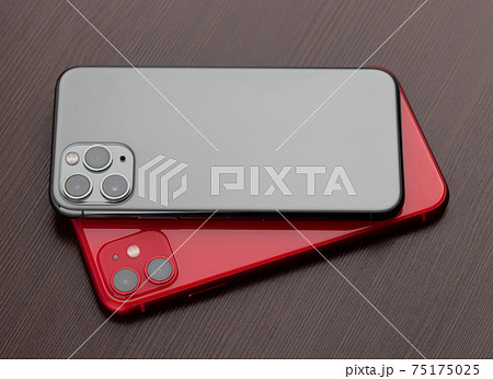 Two smartphones close-up on a wooden background. Two smartphones close-up on a wooden background. 75175025