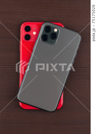 Two smartphones close-up on a wooden background. Two smartphones close-up on a wooden background. 75175026