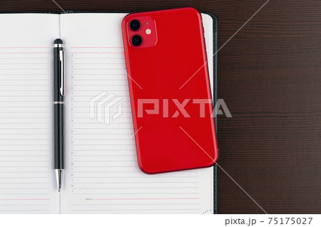 A smartphone with three cameras, a smart watch and wireless headphones on a wooden table. 75175027