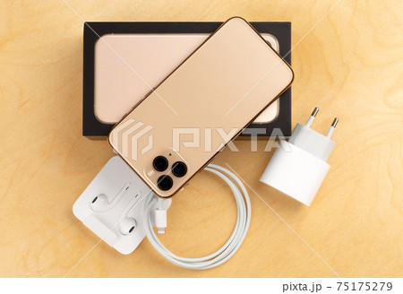 Smartphone on a wooden surface. A popular smartphone and a kit from it and a box close-up. 75175279