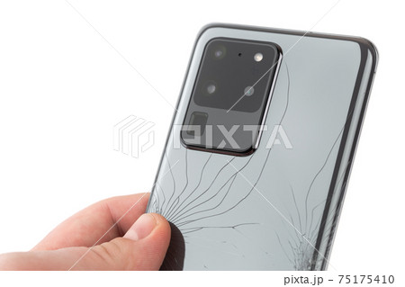 Smartphone with a broken back cover on a white background. 75175410