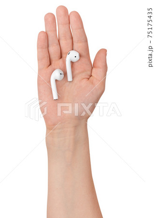 Wireless headphones in a hand on a white background. 75175435