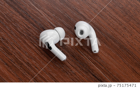 Wireless headphones on a wooden table. Wireless headset close-up. Wireless headphones on a wooden table. Wireless headset close-up. 75175471