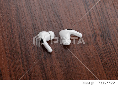 Wireless headphones on a wooden table. Wireless headset close-up. Wireless headphones on a wooden table. Wireless headset close-up. 75175472