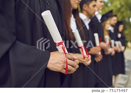 University graduates hands holding diplomas after university graduating University graduates hands holding diplomas after university graduating 75175497