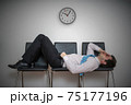 Tired bored man is sleeping in waiting room on chairs. 75177196