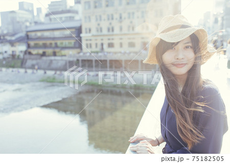 京都 橋の上 麦わら帽子をかぶったカメラ目線のロングヘアの女性 京都 橋の上 麦わら帽子をかぶったカメラ目線のロングヘアの女性 75182505