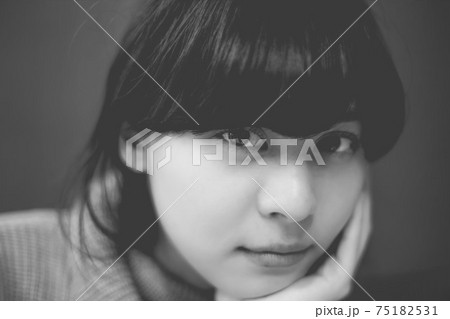 白黒写真 頬杖をついているカメラ目線の女性 モノクロ 白黒写真 頬杖をついているカメラ目線の女性 モノクロ 75182531