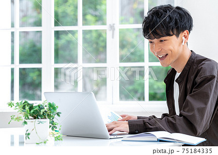 テレワークで仕事する若い男性 75184335