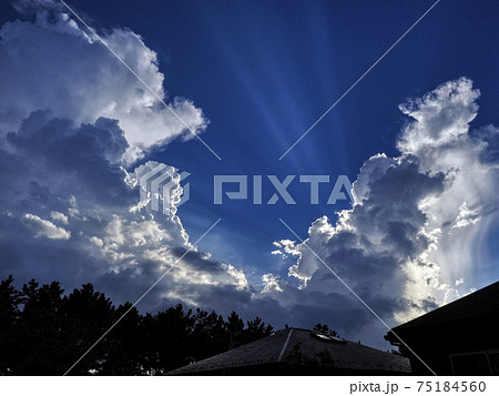 積乱雲の中から射す光芒の写真素材