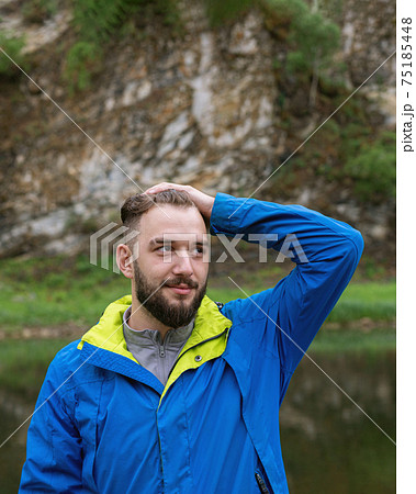 young guy stands in park with thoughtful look putting his hand on his head young guy stands in park with thoughtful look putting his hand on his head 75185448