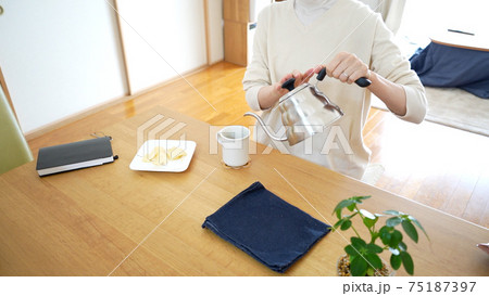 カップにお湯を注ぐ カップにお湯を注ぐ 75187397