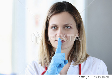 Doctor with gloves holding his index finger near his mouth Doctor with gloves holding his index finger near his mouth 75193026