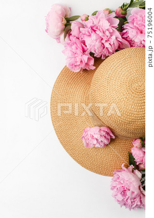 Summer, spring concept, straw braided hat, pink peony flowers on white background Summer, spring concept, straw braided hat, pink peony flowers on white background 75196004