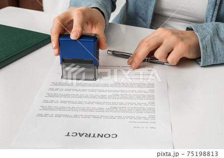 Business woman putting stamp on documents in the office 75198813