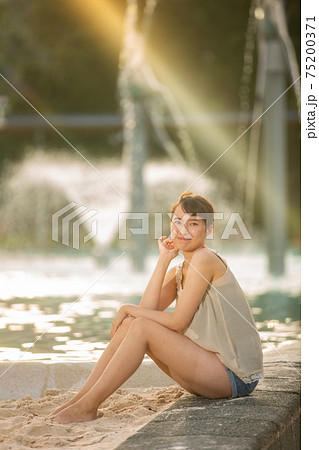 ケアンズのラグーンプールに座るハーフの美女の写真素材