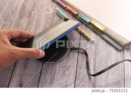 charging Smartphone using Wireless Charging Pad, top view charging Smartphone using Wireless Charging Pad, top view 75201111