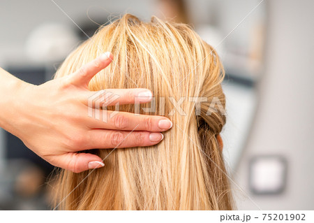 Female hairdresser styling blonde hair 75201902