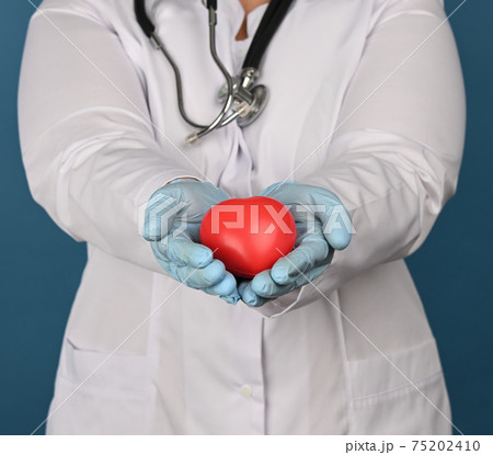 female medic in a white coat holds a red heart on a blue background 75202410