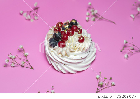 Meringue dessert with blueberries and currants on pink background 75203077