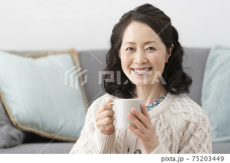 マグカップ を持った笑顔の60代半ばの女性 75203449